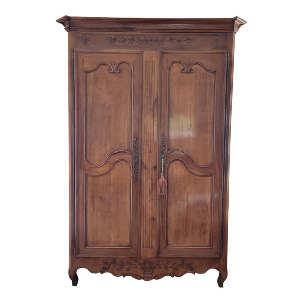 Antique brown wood armoire with carved details
