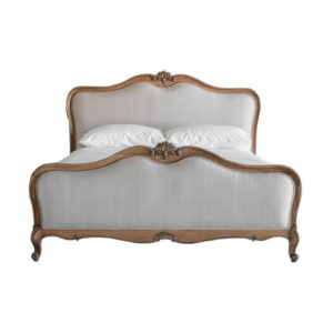 Elegant French Provincial style bed with linen upholstery and carved wood frame