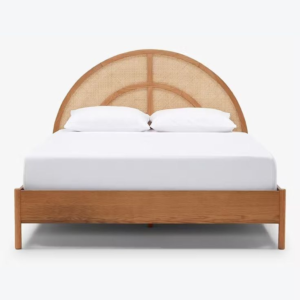 Mid-Century Modern bed with rattan headboard and natural wood frame