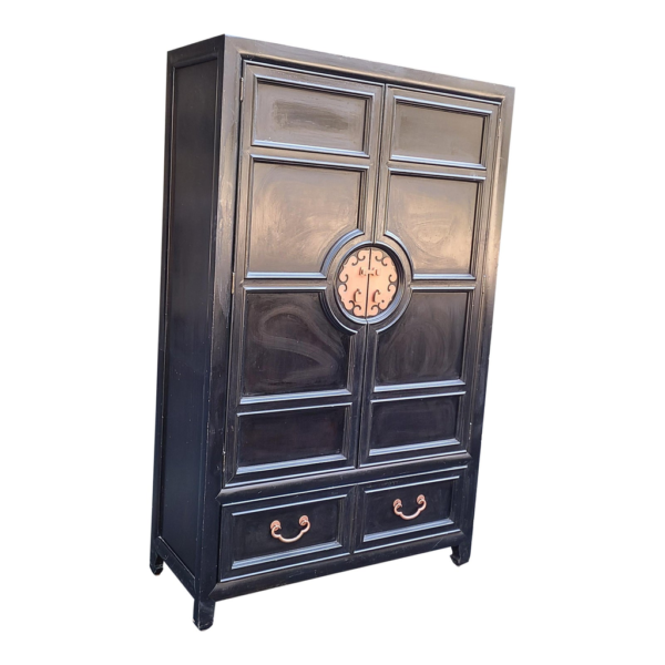 Black wood armoire cabinet with copper accents and two drawers.