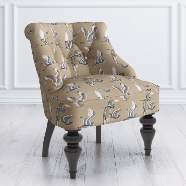 Upholstered armchair with bird pattern fabric and button-tufted details