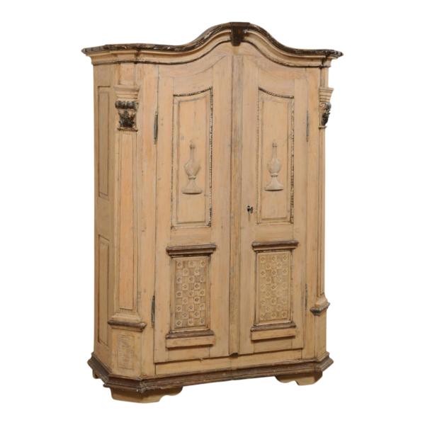 Vintage beige wood armoire with carved details.