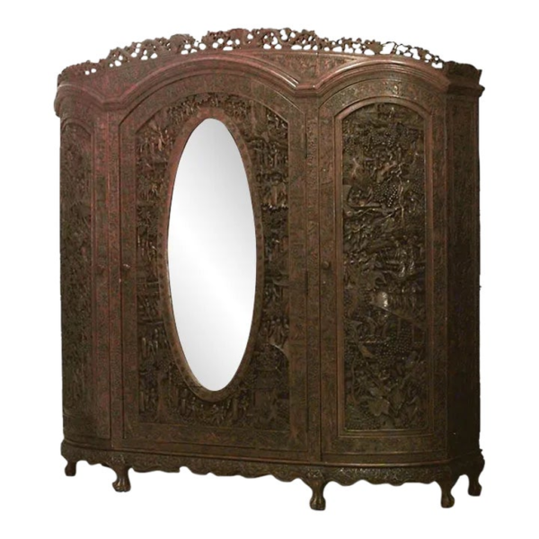 Vintage brown wood armoire with oval mirror and intricate carvings.