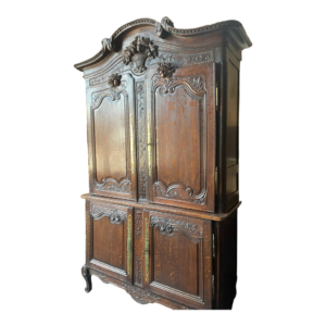 Vintage brown wooden armoire with intricate carvings.
